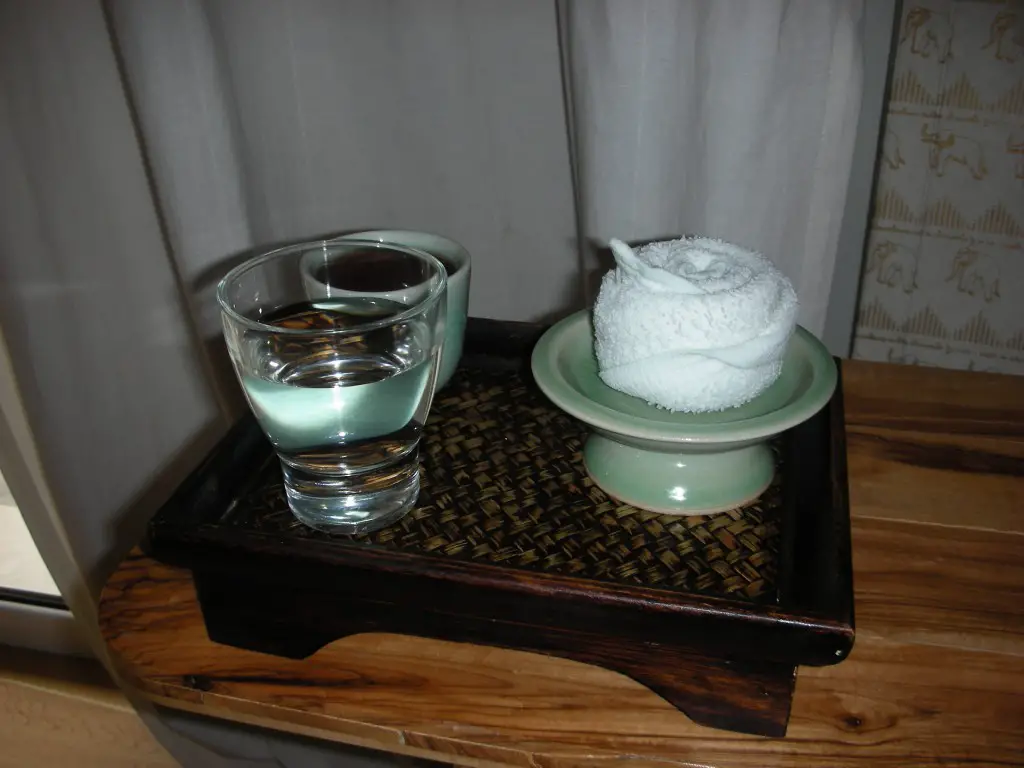 Welcoming green tea and warm face cloth
